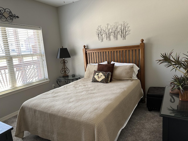 bedroom with baseboards and carpet