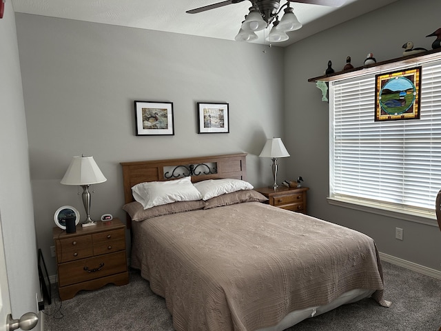 carpeted bedroom featuring baseboards and a ceiling fan