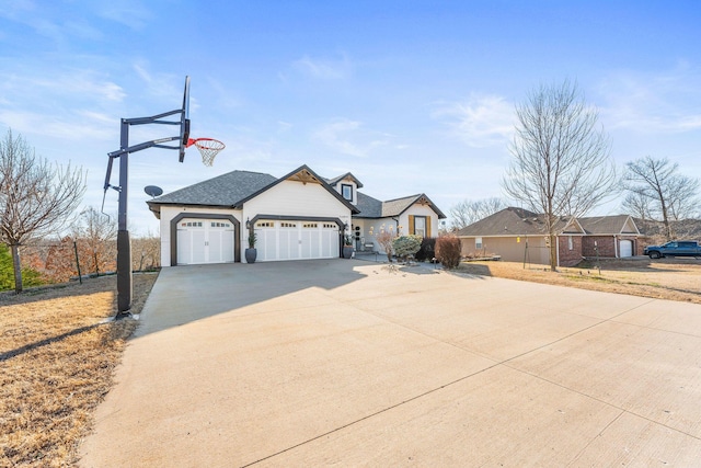 view of front facade with an attached garage, driveway, and roof with shingles