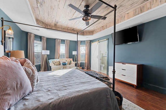 bedroom featuring baseboards, wood ceiling, a barn door, wood finished floors, and a raised ceiling