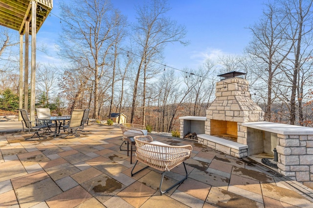 view of patio / terrace with outdoor dining space and an outdoor stone fireplace