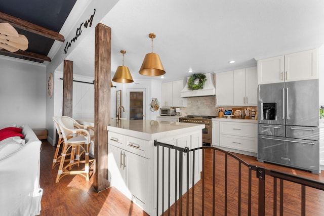 kitchen featuring backsplash, dark wood-type flooring, high quality appliances, a barn door, and custom range hood