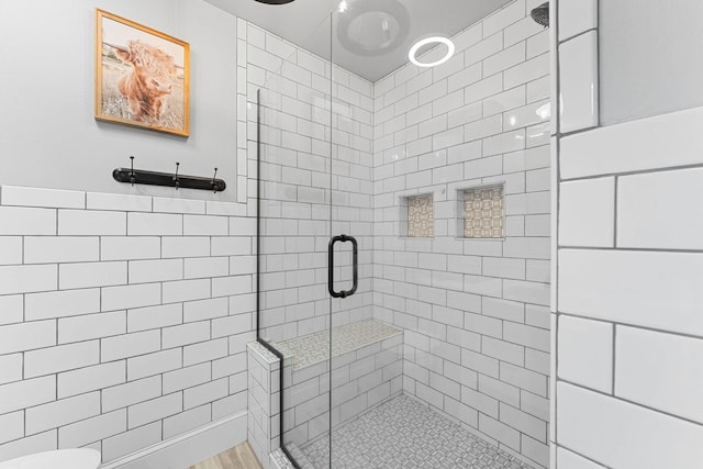 full bath with tile walls and a stall shower