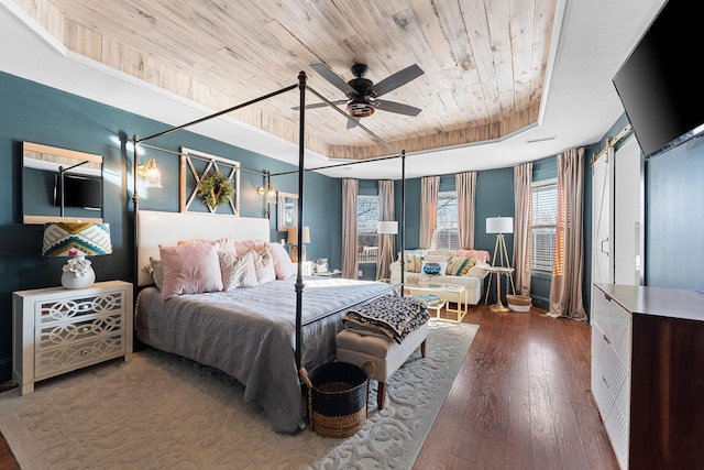 bedroom with wood ceiling, a raised ceiling, and hardwood / wood-style floors