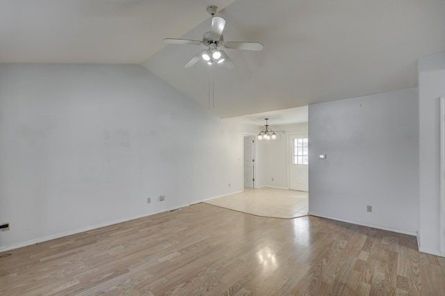 unfurnished room featuring ceiling fan with notable chandelier, light wood-type flooring, and lofted ceiling