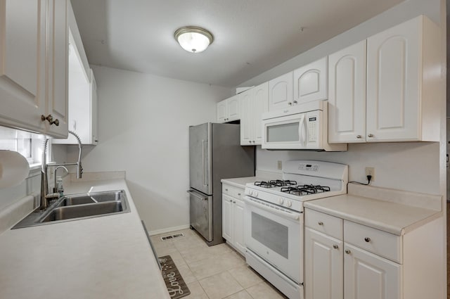 kitchen with a sink, white cabinetry, white appliances, light tile patterned flooring, and light countertops