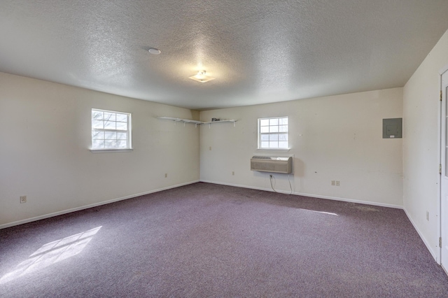 carpeted spare room with electric panel, a healthy amount of sunlight, baseboards, and a wall mounted AC