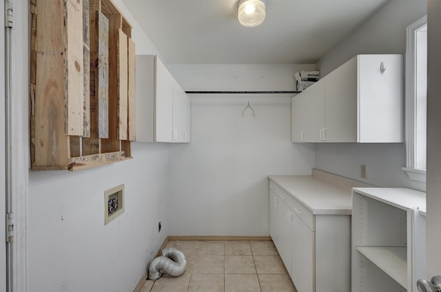 clothes washing area featuring washer hookup, light tile patterned floors, cabinet space, and baseboards