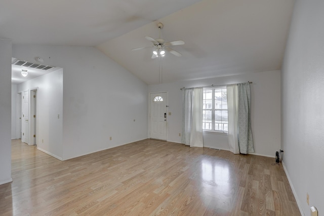 empty room featuring vaulted ceiling, light wood-style floors, visible vents, and ceiling fan