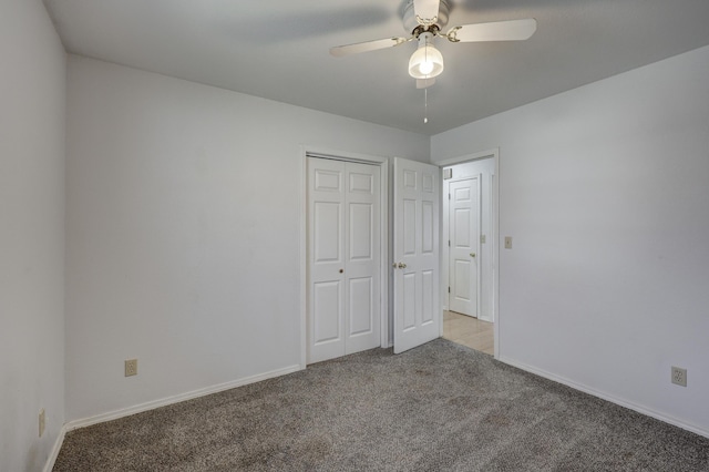 unfurnished bedroom featuring a closet, carpet floors, baseboards, and ceiling fan