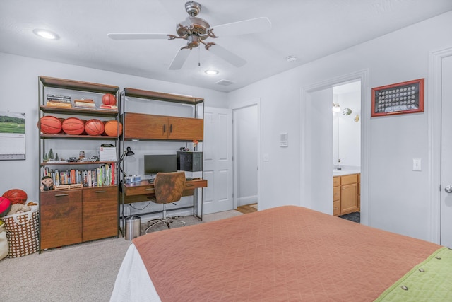 carpeted bedroom featuring connected bathroom and a ceiling fan