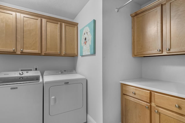 laundry room with cabinet space, washer and dryer, and baseboards