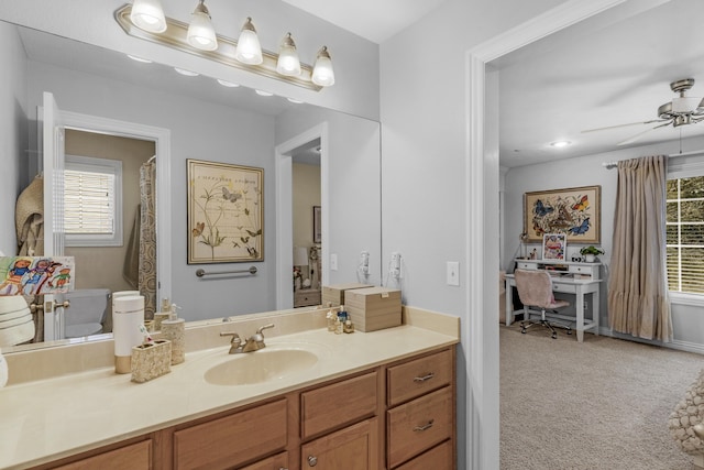 bathroom featuring a wealth of natural light, toilet, vanity, and a ceiling fan