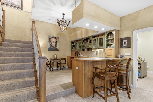 bar featuring indoor wet bar, stairway, light colored carpet, and baseboards