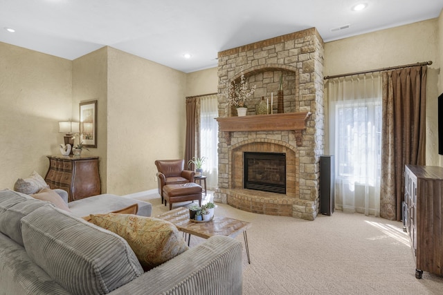 carpeted living area with visible vents, recessed lighting, a fireplace, baseboards, and a textured wall