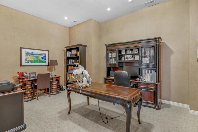 office space with baseboards, visible vents, and light carpet