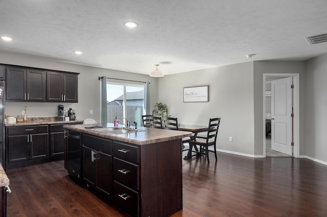 kitchen featuring black dishwasher, dark wood-style floors, visible vents, and a sink