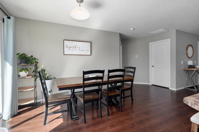 dining space with visible vents, baseboards, and wood finished floors