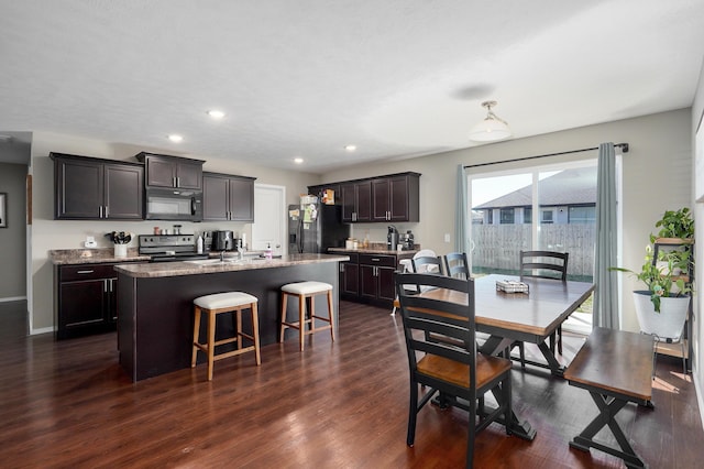 dining space featuring dark wood-type flooring, recessed lighting, and baseboards