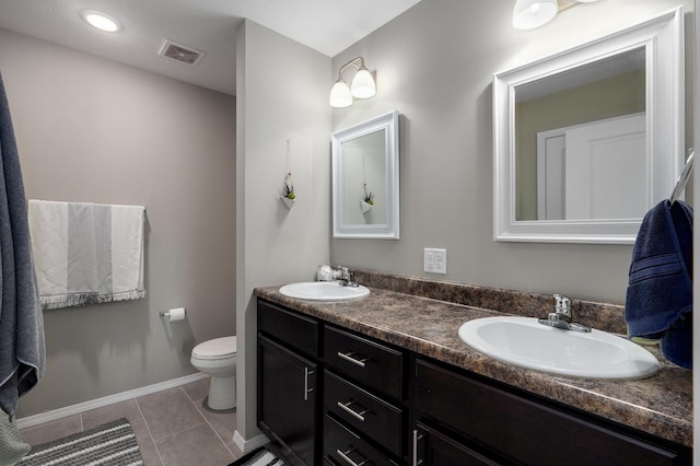 bathroom featuring tile patterned floors, visible vents, toilet, and a sink