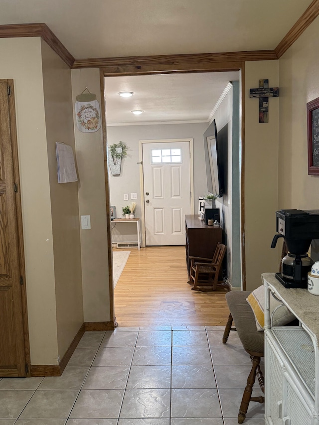 foyer entrance with light tile patterned flooring, crown molding, and baseboards