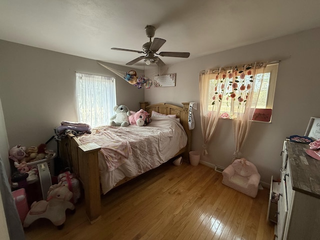 bedroom with light wood-style flooring, multiple windows, and a ceiling fan