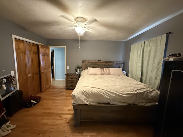 bedroom featuring a ceiling fan, light wood-type flooring, and a closet