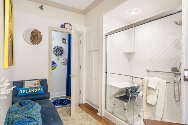 bathroom featuring baseboards, wood finished floors, a stall shower, and ornamental molding