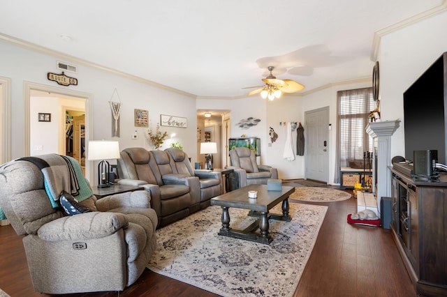 living area with crown molding, a ceiling fan, visible vents, and dark wood-style flooring