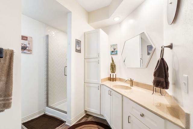 full bath featuring vanity, wood finished floors, and a shower stall