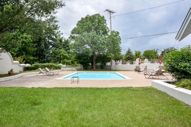 view of pool with a yard, a patio, a fenced in pool, and fence