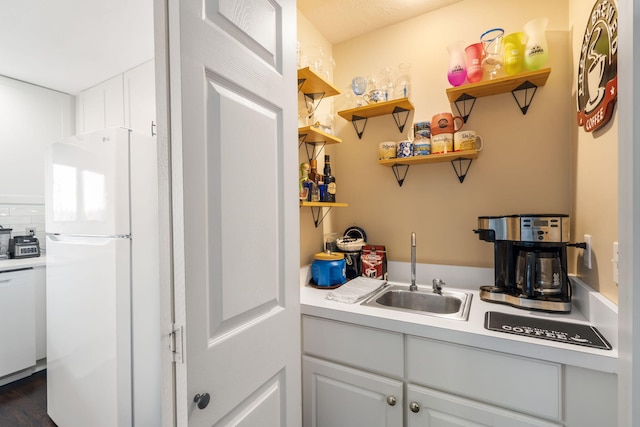 kitchen featuring white appliances, light countertops, open shelves, and a sink