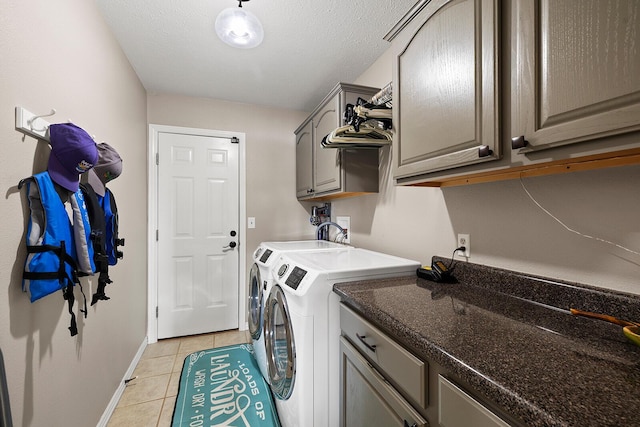 laundry area featuring independent washer and dryer, a textured ceiling, cabinet space, light tile patterned floors, and baseboards