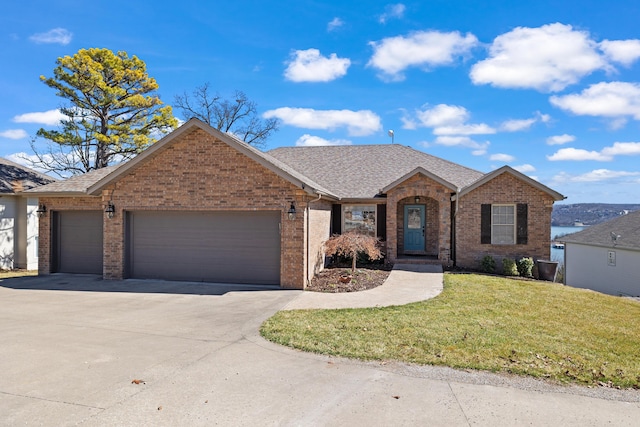 ranch-style house featuring an attached garage, a shingled roof, a front lawn, concrete driveway, and brick siding