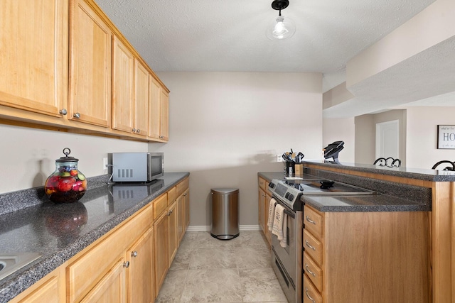 kitchen featuring light brown cabinetry, a textured ceiling, stainless steel appliances, a peninsula, and baseboards