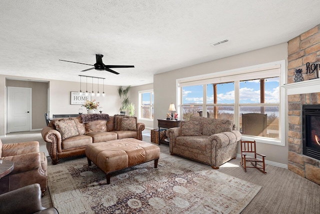 living room featuring visible vents, a fireplace, and a textured ceiling