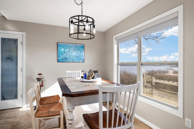 dining area featuring baseboards and an inviting chandelier