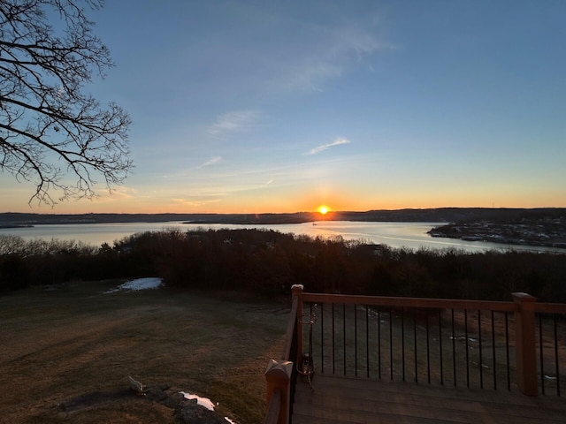 yard at dusk featuring a water view