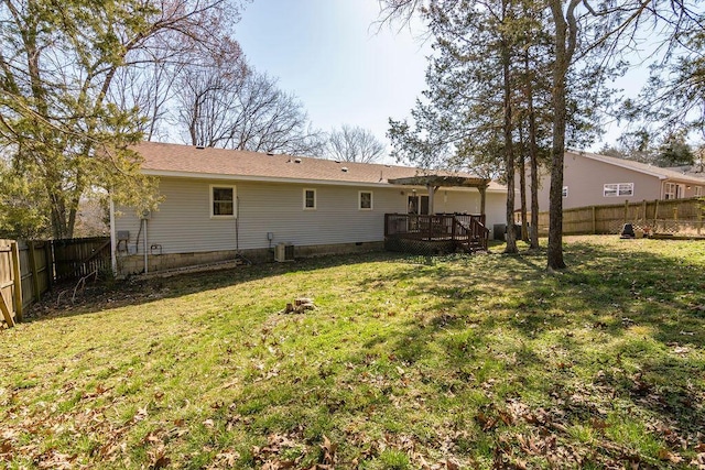 back of house with crawl space, a deck, a lawn, and a fenced backyard