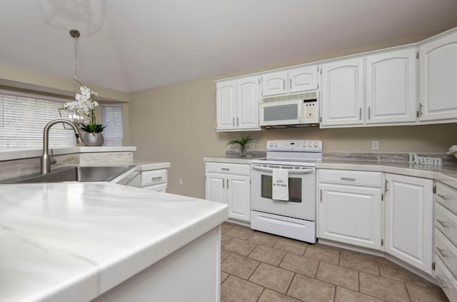 kitchen with a sink, white appliances, white cabinets, and light countertops