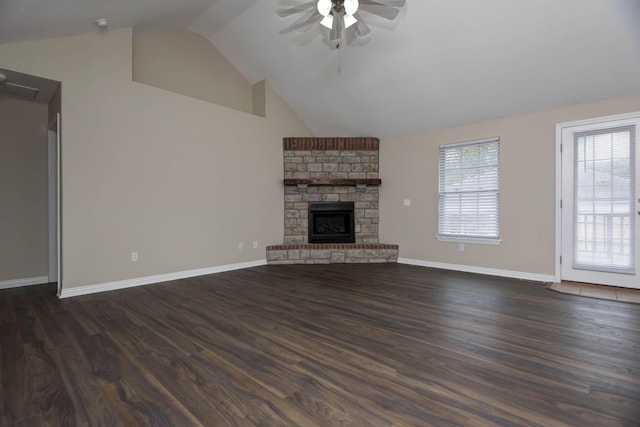 unfurnished living room featuring a stone fireplace, dark wood-style floors, baseboards, and a ceiling fan