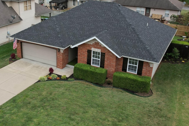 single story home with a front yard, brick siding, roof with shingles, and an attached garage