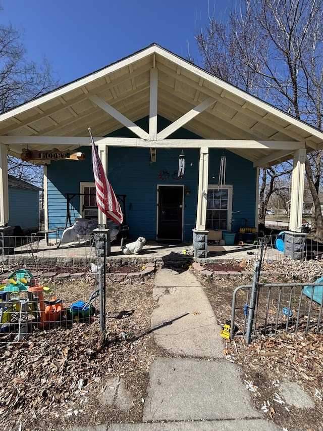 doorway to property with a porch and fence