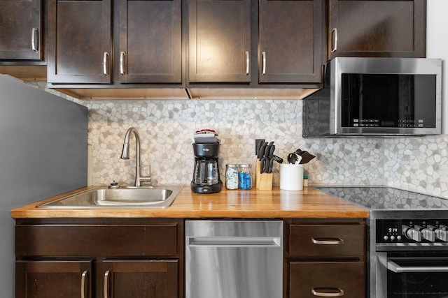 kitchen with dark brown cabinets, appliances with stainless steel finishes, and a sink