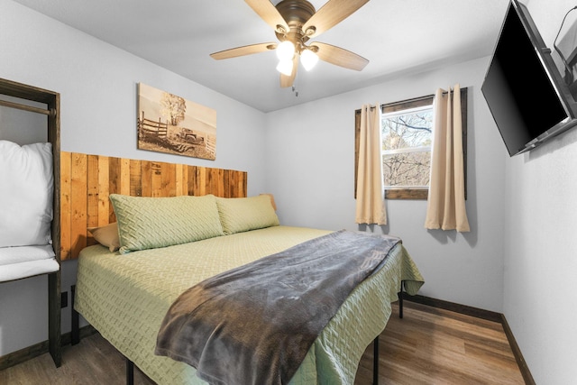 bedroom with a ceiling fan, wood finished floors, and baseboards