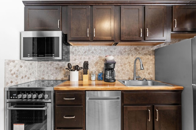 kitchen featuring wooden counters, dark brown cabinets, appliances with stainless steel finishes, and a sink