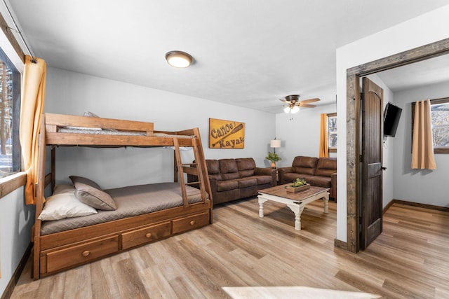 living area featuring a ceiling fan, wood finished floors, and baseboards