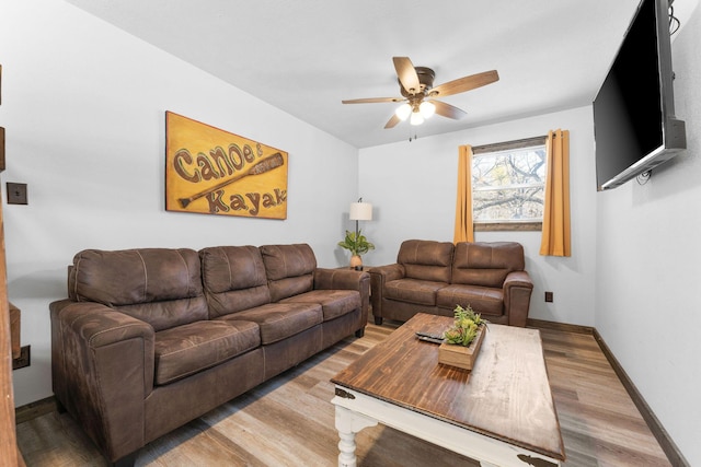 living room with baseboards, light wood-style floors, and ceiling fan