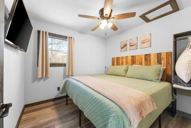 bedroom with a ceiling fan, baseboards, and wood finished floors