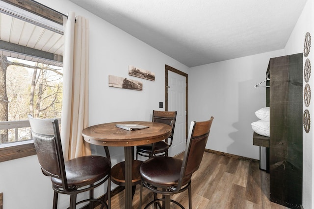 dining space with wood finished floors and baseboards